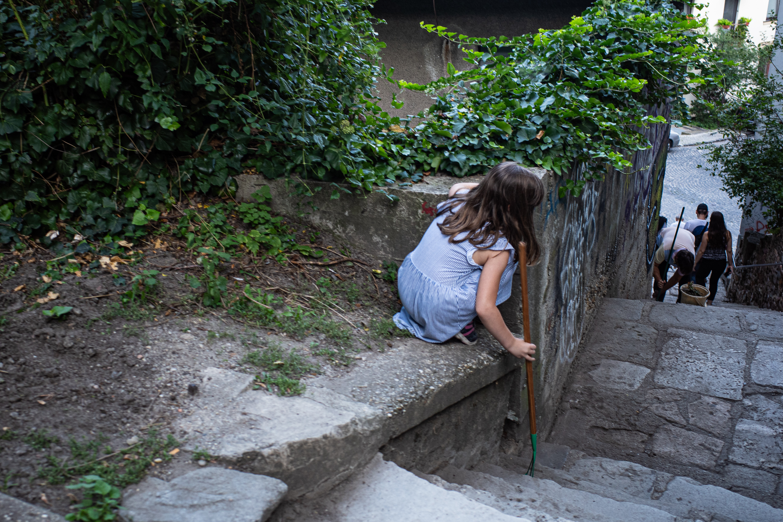 Ein Mädchen klettert die Mauer entlang der Treppengasse hinauf
